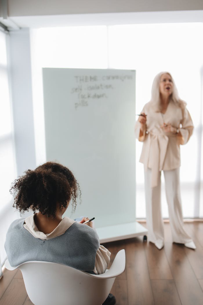 A teacher engages with a student in a classroom setting, fostering an interactive learning environment.